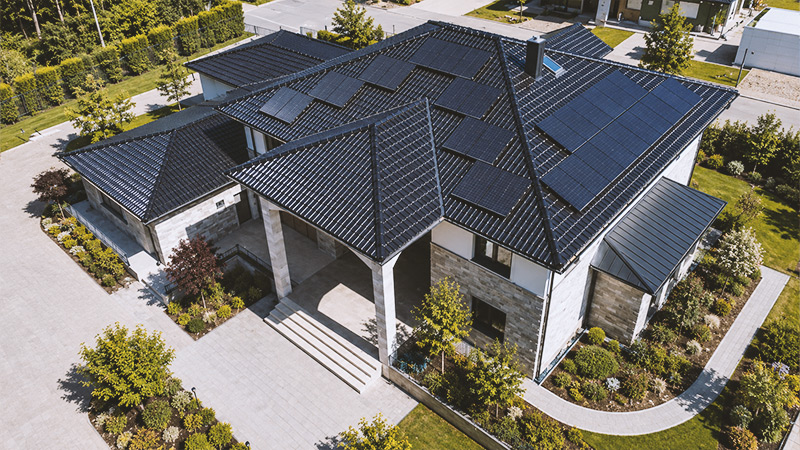 Luftaufnahme eines modernen Einfamilienhauses mit Photovoltaikanlage während der Bauphase.