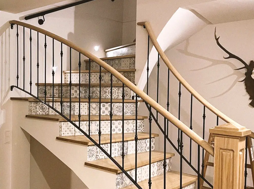 Geschwungene Holztreppe mit Stahlgeländer im Innenbereich eines Einfamilienhauses.